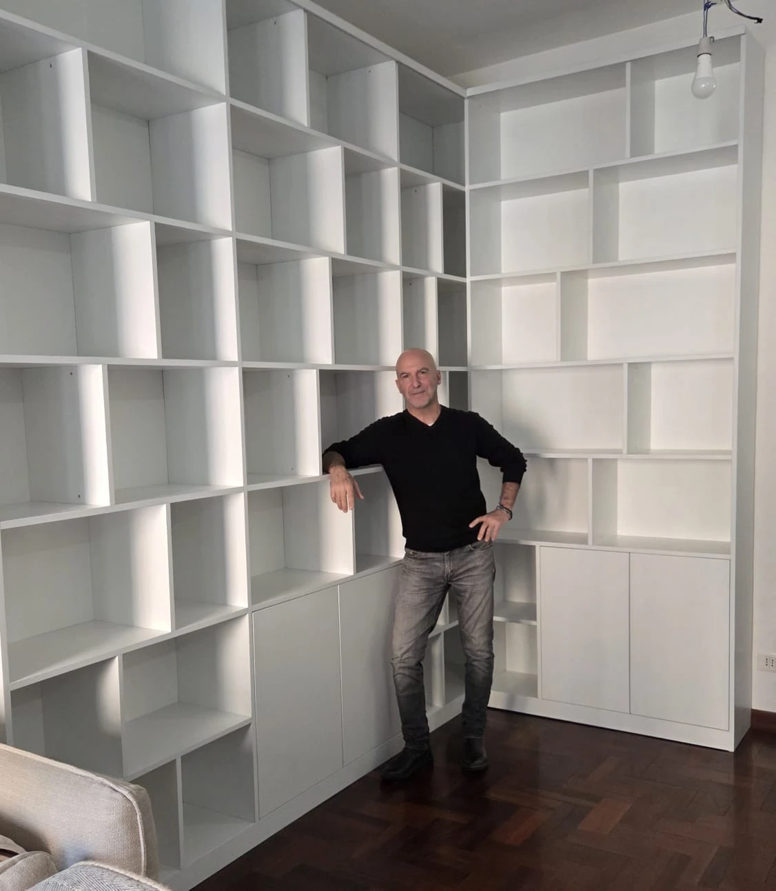 Alessandro Ziggiotti, titolare di PECS23, appoggiato a una libreria bianca su misura