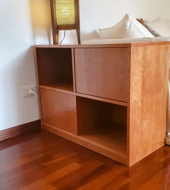 Mobile basso in legno con vani aperti e ante, in un angolo del soggiorno